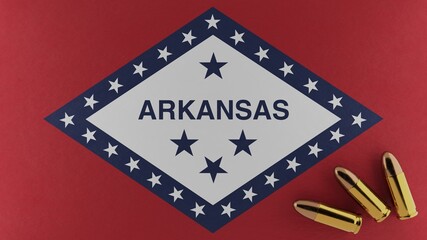 Three 9mm bullets on the bottom right corner on top of the United States state flag of Arkansas