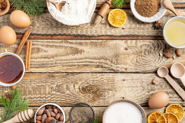 Frame of Ingredients for cooking Christmas baking and gingerbread cookies on a wooden background, top view. New Year, holidays, copy space