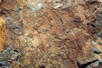 Rock texture. Stone background. Old weathered crumbling mountain surface in cracks background. Light brown rock background.
