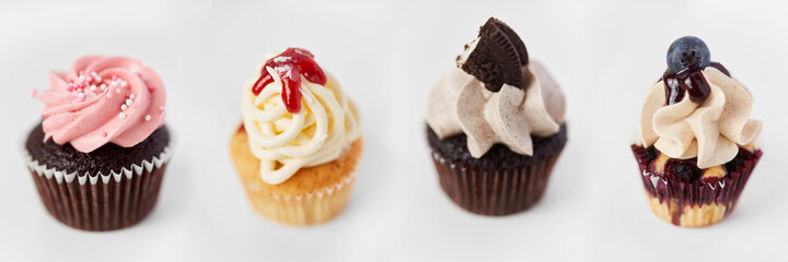Viele dekorierte bunte Cupcakes mit Toppings in Reihe