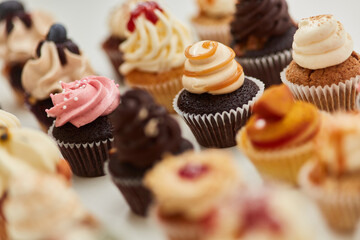 Viele verschiedene kleine Cupcakes mit Topping