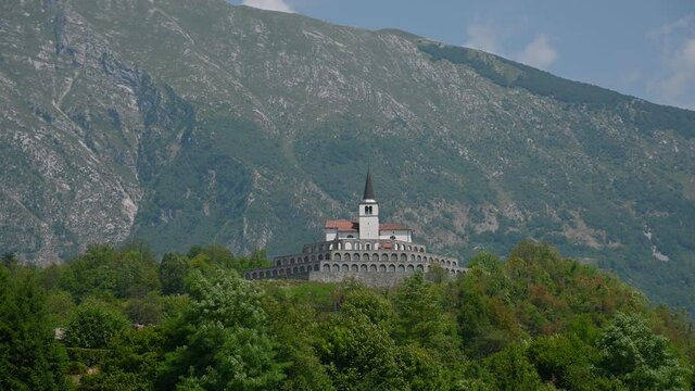 Low angle view of Italian ossuary in Kobarid, Slovenia. Military cemetery charnel house. Monument in memory of fallen Italian soldiers. Church of St. Anton on the top. Static, establishment shot