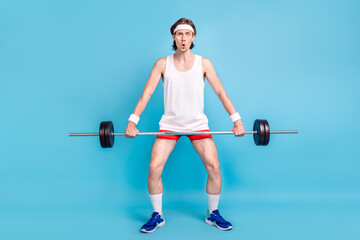 Full length body size photo man keeping barbell wearing sportswear isolated pastel blue color...