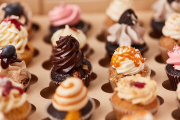 Viele kleine bunte dekorierte Cupcakes in Konditorei