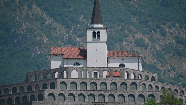 Low angle view of Italian ossuary in Kobarid, Slovenia. Military cemetery charnel house. Monument in memory of fallen Italian soldiers. Church of St. Anton on the top. Static, establishment shot