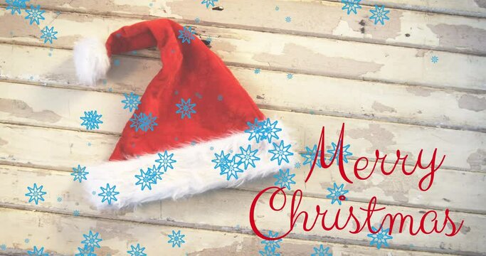 Animation of merry christmas text over santa hat and snow falling