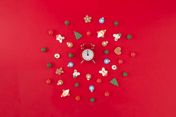 Christmas wreath of cookies with red o'clock on the red background. Time for Christmas. Christmas holiday creative concept.