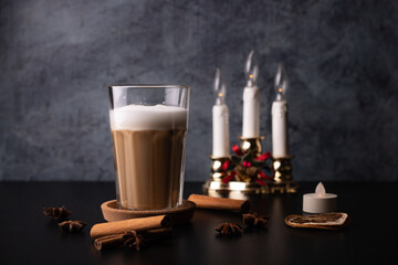 spice coffee with milk and foam, cinnamon sticks on blach background. christmas drink, chai latte....