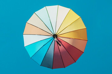 Multicoloured sun protective umbrella against a blue sky
