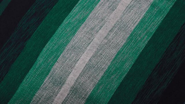 Hand-loomed traditional Moroccan bedcover, throw, from cactus silk and wool, in shades of green. Abstract fabric background.