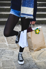 Close up of a caucasian young girl on the street with some bags after shopping. Vertical. With copy-space.