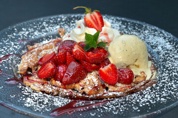Leckere Waffel mit Erdbeeren und einer Vanille Eiskugel