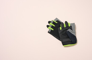pair of black sports gloves for doing sports and riding bike on a beige background