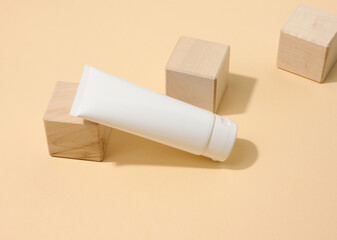 empty white plastic tubes for cosmetics on a white table. Packaging for cream, gel, serum, advertising and product promotion