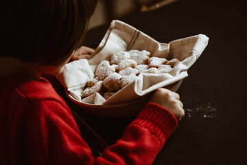 Child looks at a basket of cookies