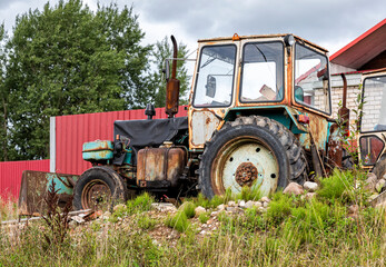 Old rusty wheeled tractor at the village