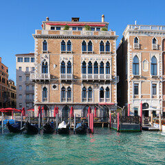 Fototapeta na wymiar Architecture of Venice, Italy. Gondola boats moored by the house. Palazzos and historic houses in the water of Grand Canal. Traditional Venetian architecture.
