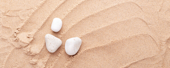Fototapeta na wymiar White stones on the sand background. Top view