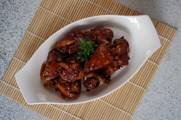 a plate of chicken cooked in butter sauce