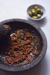 chili pepper sauce in a stone grinder or sambal