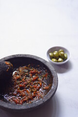 chili pepper sauce in a stone grinder or sambal