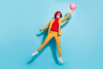 Full length body size view of attractive amazed girl jumping holding helium ball having fun isolated over bright blue color background