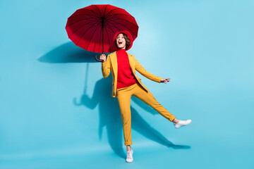 Full body photo of young excited girl happy positive smile rainy weather fall umbrella isolated over blue color background