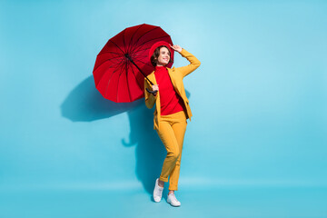 Photo of cute sweet lady wear yellow blazer red cap smiling under open parasol looking empty space...
