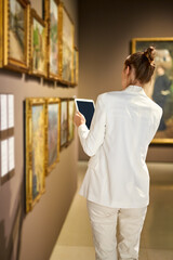 Woman visitor in the historical museum looking at pictures