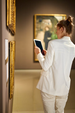 Woman visitor in the historical museum looking at pictures