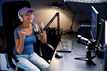 Beautiful Woman In A Cap And White Headphones Leads A Live Stream
