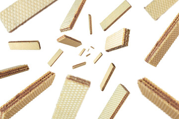 Collection of crispy wafers filled with chocolate cream falling isolated on white background. Selective focus