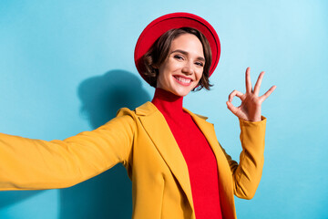 Photo of cute adorable young woman dressed red headwear recording video showing okey isolated blue color background