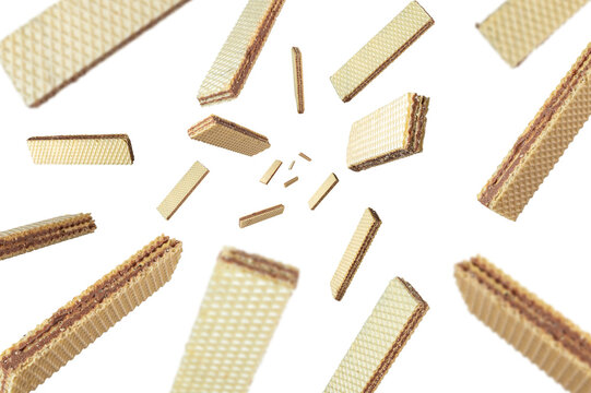 Collection of crispy wafers filled with chocolate cream falling isolated on white background. Selective focus