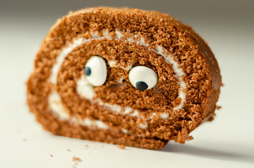 Chocolate sponge roll with a vanilla flavour filling with decorating sweet eyes, chocolate swiss roll