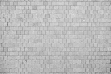 Texture of small cobblestones of a sidewalk or street. Gray cobblestones. Cement squares. Square...