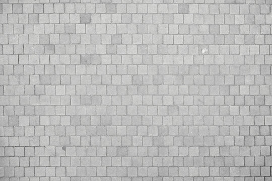Texture of small cobblestones of a sidewalk or street. Gray cobblestones. Cement squares. Square stone. Texture for matte painting.