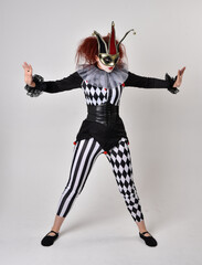 Obraz premium halloween, character, costume, figure pose, posing, portrait, gesture, isolated, magical, dynamic movement, isolated, studio background, red hair, circus, theatre, jester, clown, full length,