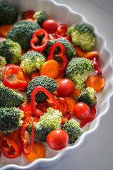 Vegetables for baking broccoli, peppers, tomatoes, carrots close-up. Healthy food, vegan cuisine background