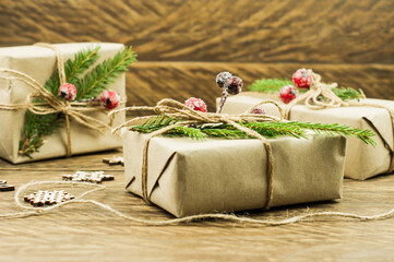 Fototapeta na wymiar Christmas gift or present boxes wrapped in craft paper with decoration on rustic wooden background.