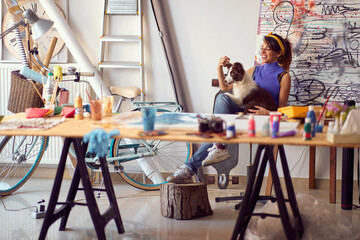 Woman painter at workspace with her dog.Art, creativity and inspiration concept