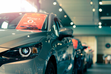 Selective focus grey car parked in luxury showroom. Car dealership office. New car parked in modern...