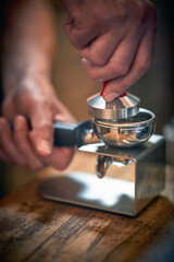 Fototapeta na wymiar Close-up view of a barman's hands preparing an espresso. Coffee, beverage, bar