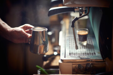 A barman is using an espresso apparatus. Coffee, beverage, bar