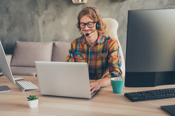 Photo of young guy happy positive smile wear headphones type computer work online help line programmer indoors