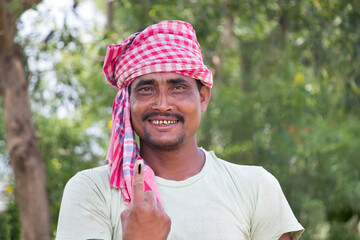 Portrait of farmer with voters mark on finger In Agricultural Field
