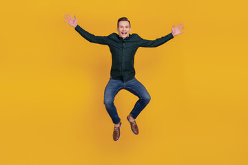 Fototapeta na wymiar Full body photo of young cheerful man have fun jump up activity isolated over yellow color background