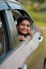 Cute Indian Child waving from car window.