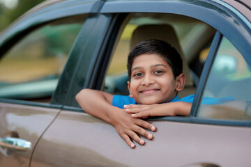 Cute Indian Child waving from car window.