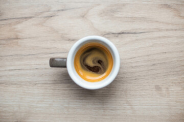 Cup with espresso on a white wood top view. Espresso. Coffee creams.